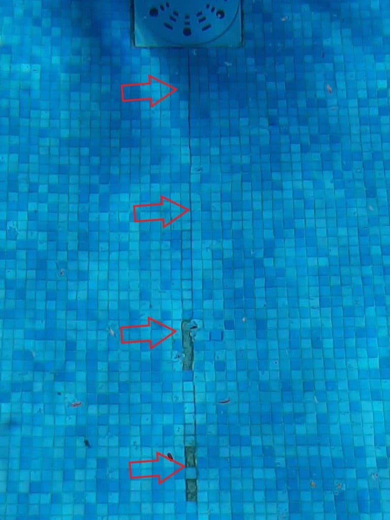 grosse fissure sur le sol d'une piscine carrelée