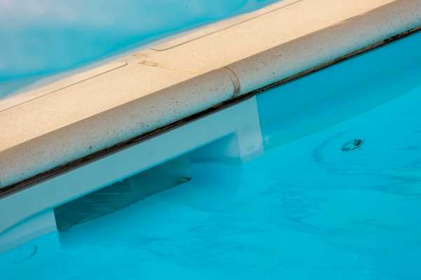 skimmer sur une petite piscine entérrée avec un liner bleu