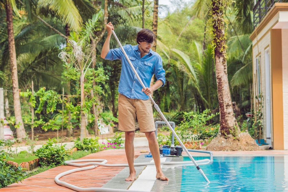 homme nettoyant la piscine pour éviter les chloramines